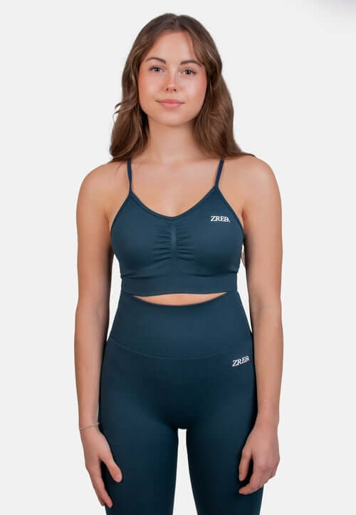 Model wearing Shape Seamless Sports Bra in teal paired with matching leggings from ZRED.
